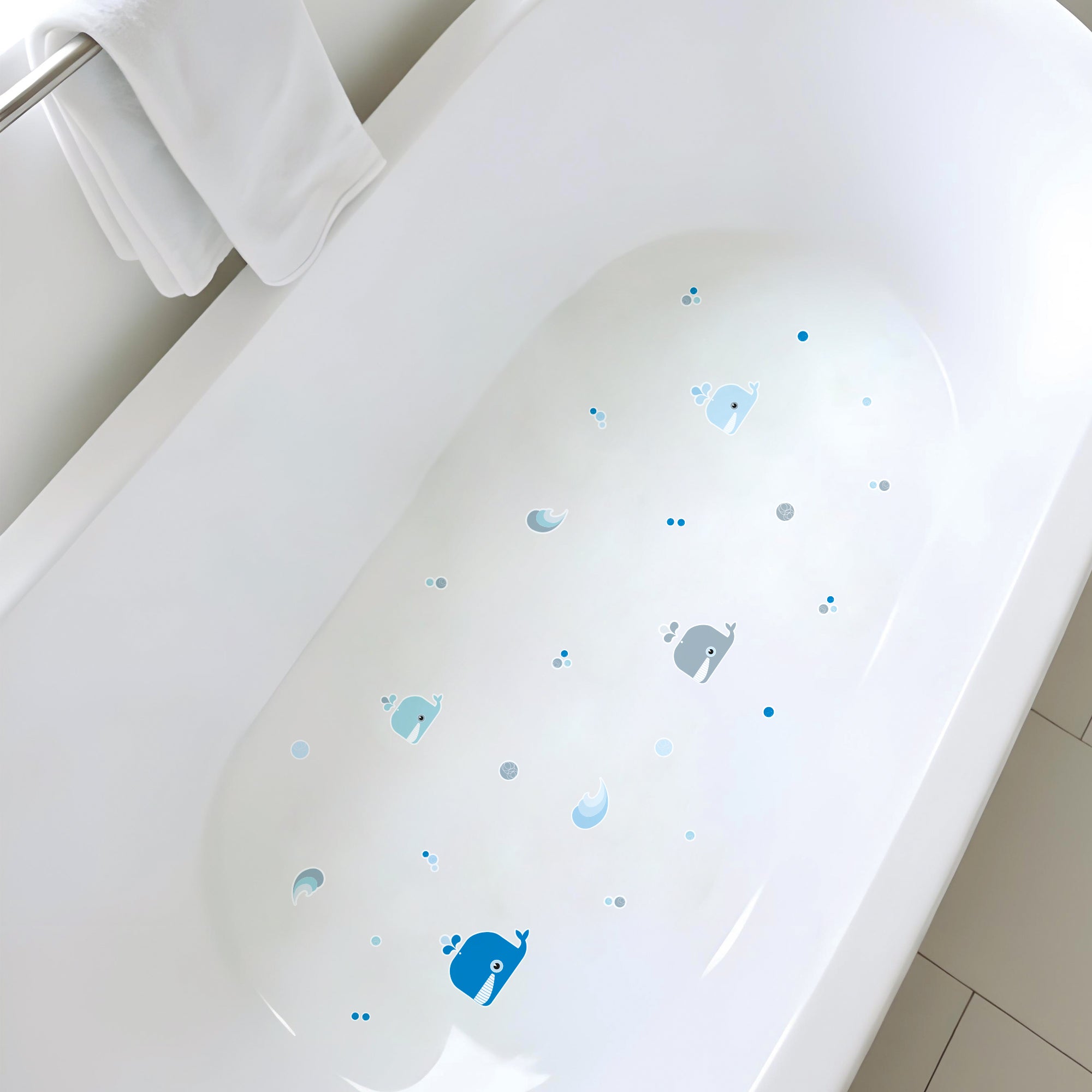 plano detalle de bañera con fondo blanco y con 4 pegatinas antideslizantes infantiles en forma de ballenas de color azul y olas para evitar resbalones durante el baño - Nicolasito.es #color_Azul