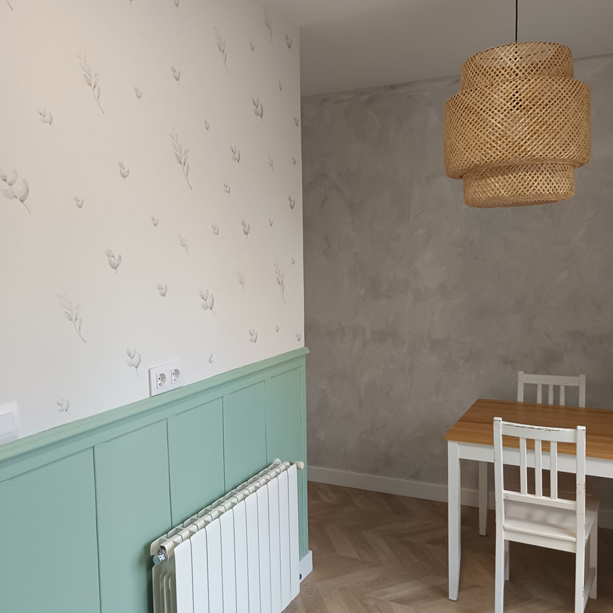 plano detalle de cocina minimalista con detalles en madera y paredes blancas decoradas a la mitad por vinilos decorativos de pared en forma de hojas y ramas verdes con efecto acuarela de varios tamaños #tamaño_Mediano