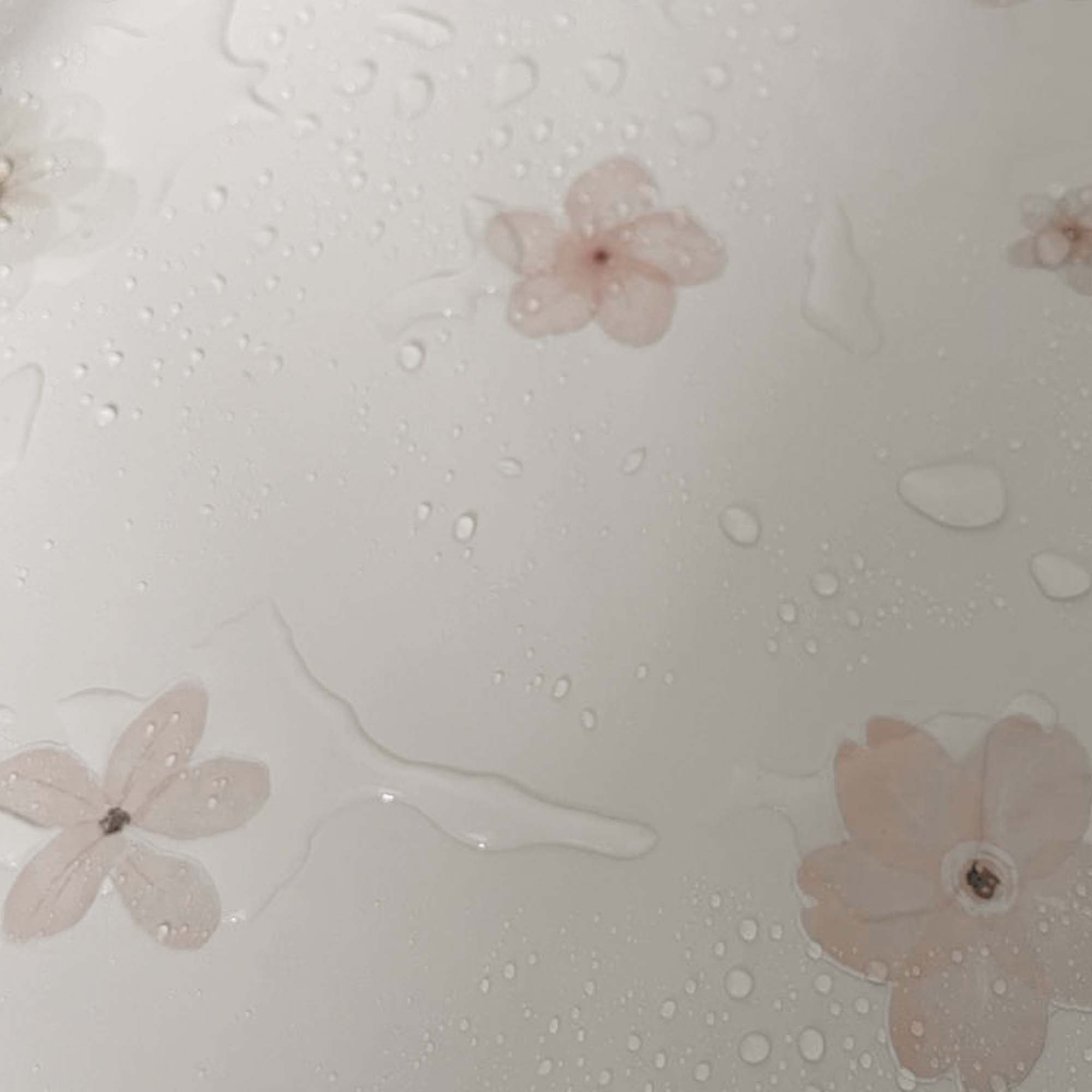 Primer plano de una pegatina de flor rosa adherida en un fondo de bañera con agua, destacando su diseño decorativo, funcionalidad antideslizante y aguante al agua - Nicolasito.es