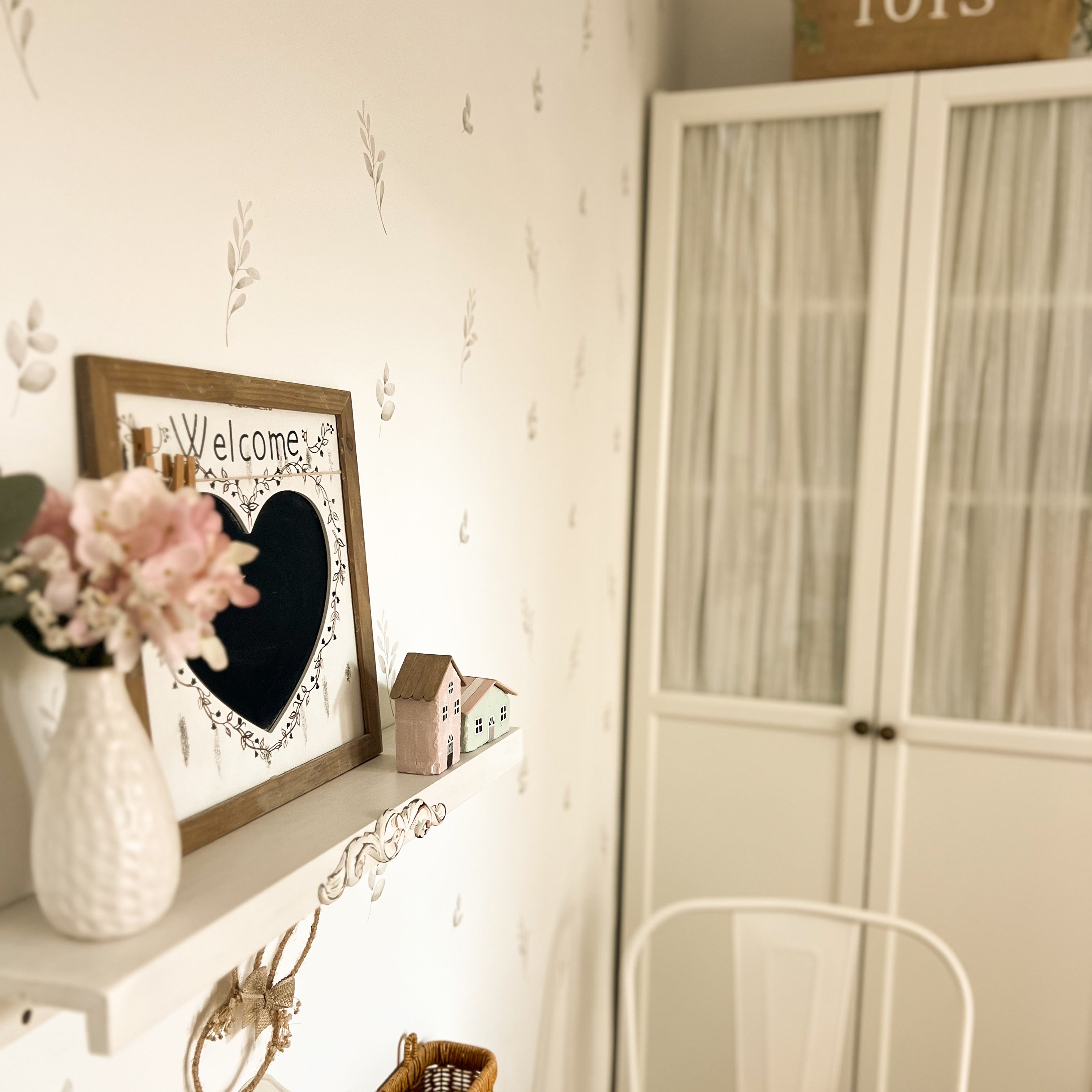 Primer plano de una habitación con decorácion natural y paredes blancas decoradas con plantas de estilo bohemio verdes, creando un espacio natural. Los vinilos decorativos son fáciles de aplicar y no dejan marcas en la pared - Nicoalsito.es #tamaño_Pequeño