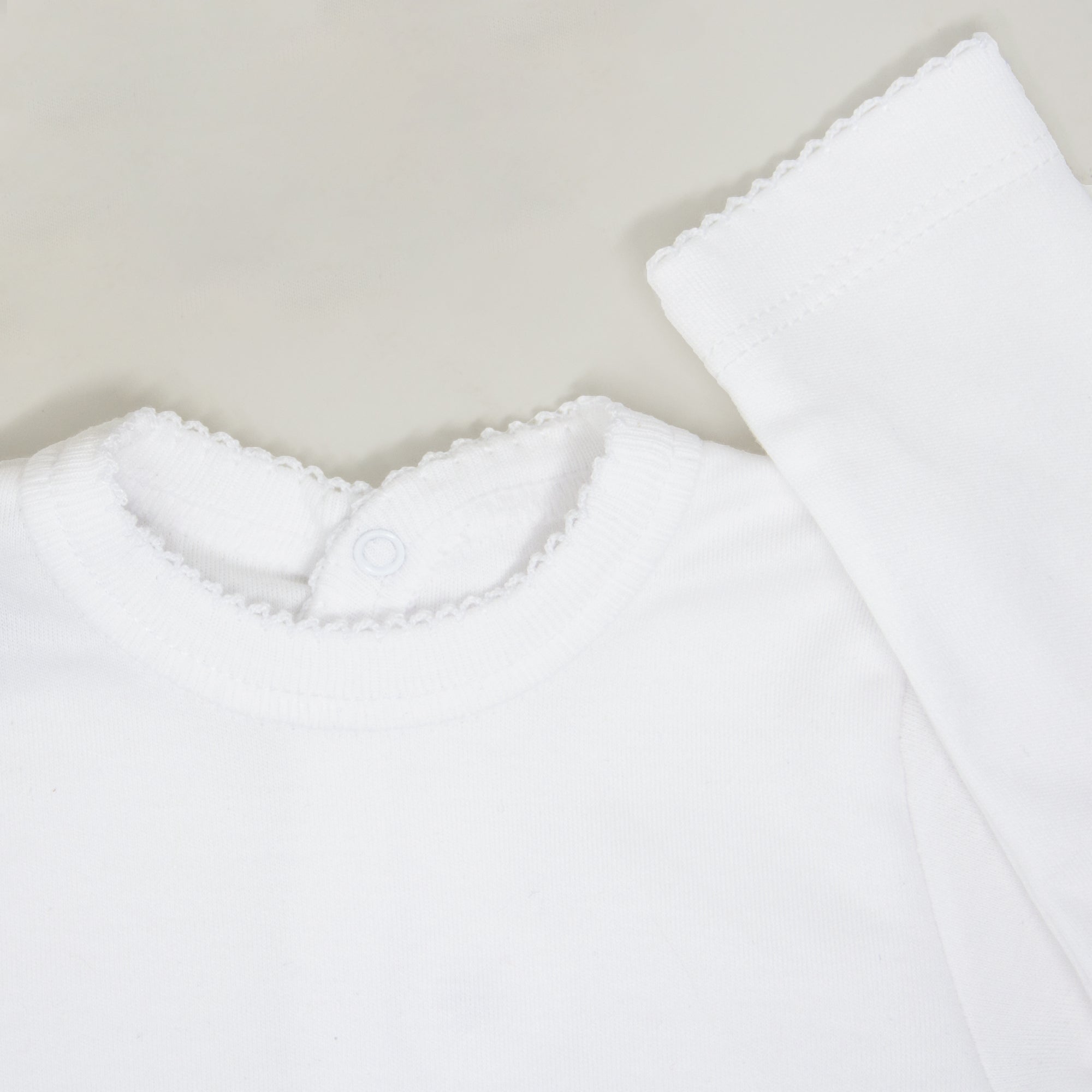 Detalle de la camisetita de manga larga del conjunto de primera puesta Mi Primera Navidad personalizado, con diseño navideño y tejido de algodón orgánico - Nicolasito.es