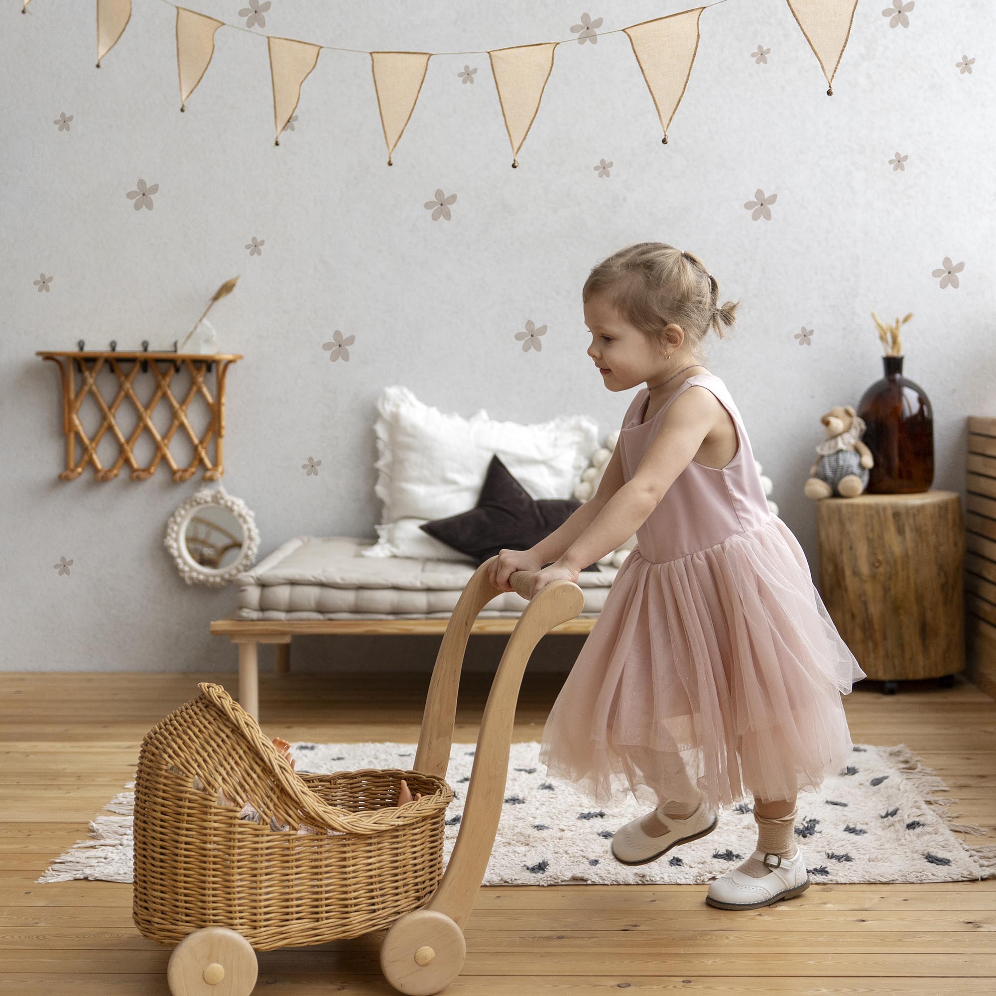 Vinilo adhesivo con diseño de flores boho de color rosa, decorando pared de habitación infantil con estilo minimalista y detalles en madera y con tonos tierra. Vinilo adhesivo fácil de colocar y de retirar - Nicolasito.es #color_flores-boho-rosa