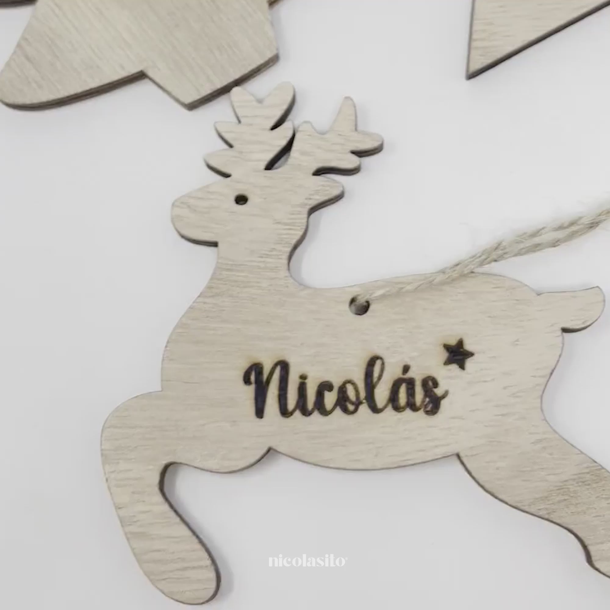 Vídeo de adornos de Navidad personalizados mostrando los modelos estrella, árbol y reno con nombre grabado, perfectos para decorar el árbol, regalar en familia y reutilizar cada Navidad. Incluye detalle del grabado, materiales y presentación final en el árbol - Nicolasito.es