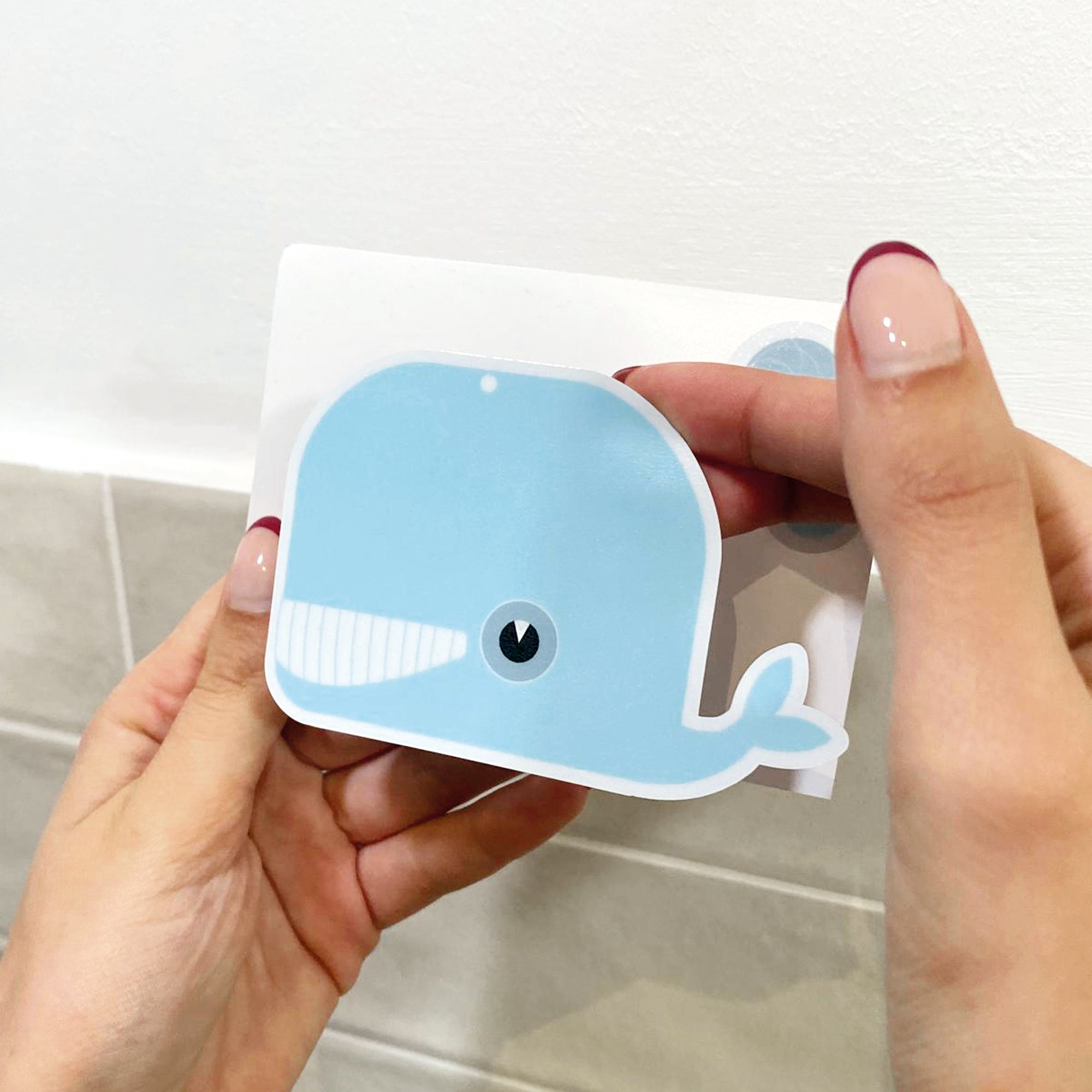 Colocación de vinilos antideslizantes infantiles en forma de ballenas de color azul para bañeras y duchas evitando resbalones y enseñando con detalle el vinilo - Nicolasito.es