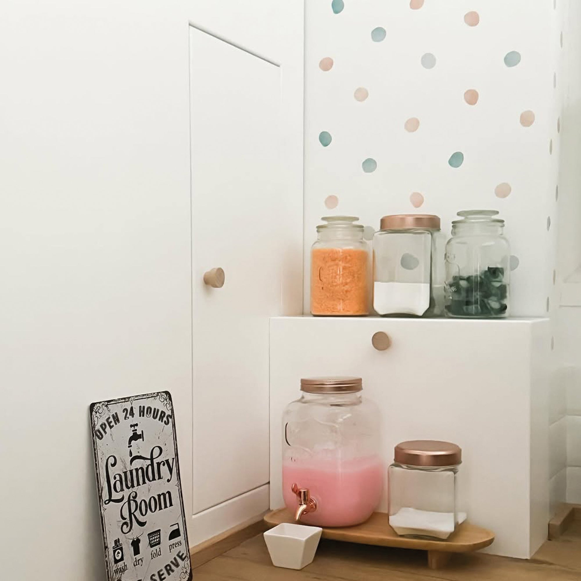 Vista general de decoración de lavandería con paredes blancas y decoradas con stickers de pared en forma de topitos de colores con acabado efecto acuarela #color_topitos-aqua