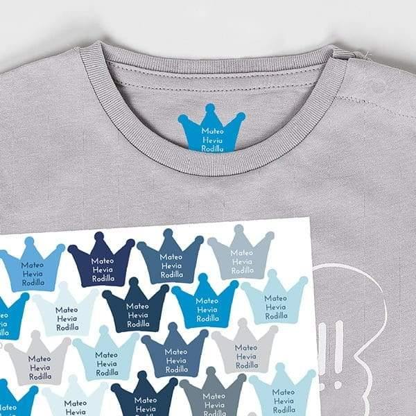 Plano detalle de etiquetas personalizadas con forma de coronas de color azul sobre camiseta infantil. Etiquetas termoadhesivas fáciles de colocar con plancha doméstica - Nicolasito.es #color_Azul