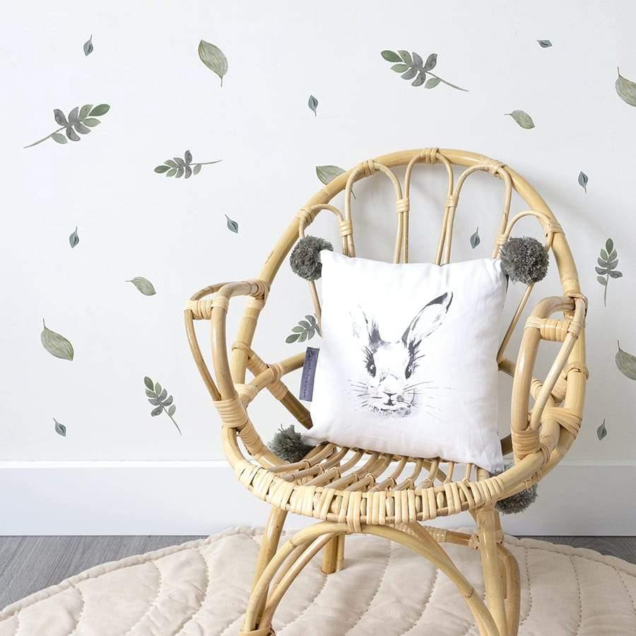 Vinilos adhesivos de hojas de plantas estilo acuarela colocados en pared blanca infantil. Nicolasito.es