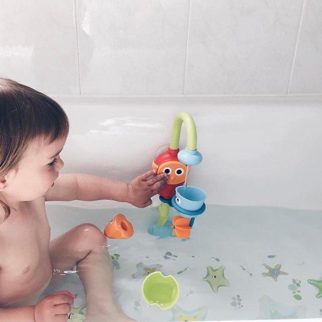 Imagen de una niña jugando dentro de una bañera llena de agua sobre la que se colocan pegatinas antideslizantes en forma de estrellas de mar de color verde y creando un ambiente seguro sin resbalones - Nicolasito.es #color_Verde