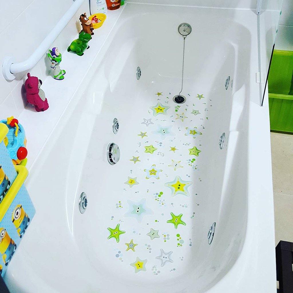 Plano detalle de bañera blanca con pegatinas antideslizantes infantiles en forma de estrellas de mar de color verde que evitan resbalones durante el baño - Nicolasito.es #color_Verde