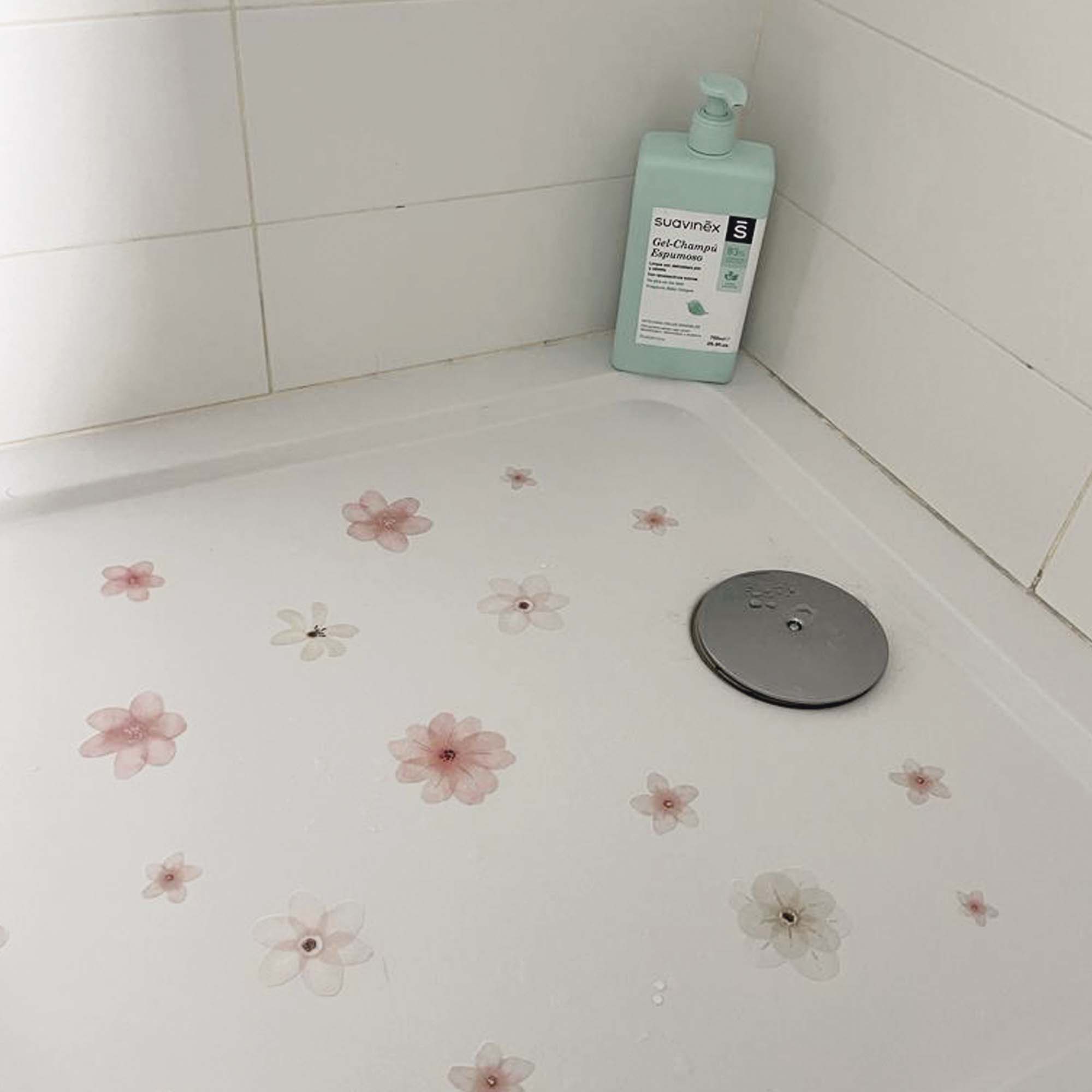 Imagen de una ducha moderna con las pegatinas de flores rosas aplicadas en el suelo, combinando seguridad y estilo en el baño - Nicolasito.es