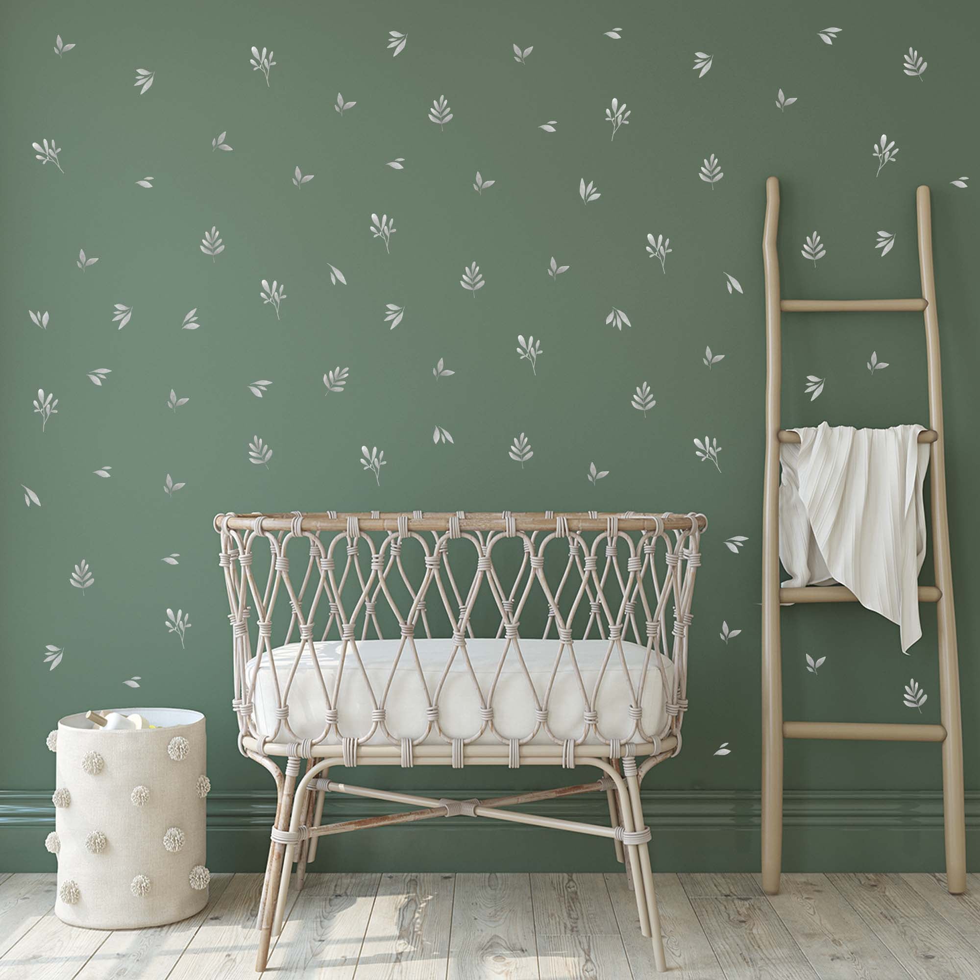 Pegatinas de hojas con efecto acuarela aplicadas sobre una pared de bebé en color verde, complementando la decoración con un toque botánico. Nicolasito.es #color_plantas-acuarela-gris