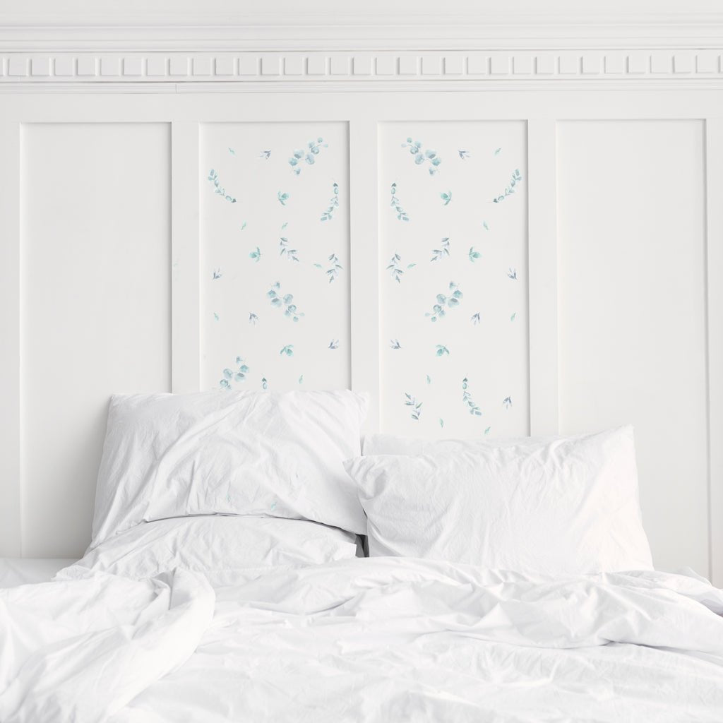 Estancia de dormitorio minimalista con paredes blanca y cabecero decorado con vinilo adhesivo de paredes modelo plantas eucalipto de color verde. Vinilo adhesivo fácil de colocar - Nicolasito.es #color_plantas-eucalipto-verde
