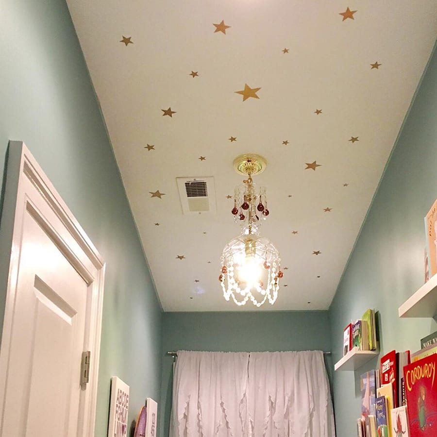 Vinilo decorativo estrellas mix en color dorado aplicado en pared de techo blanco de habitación infantil. #color_Oro