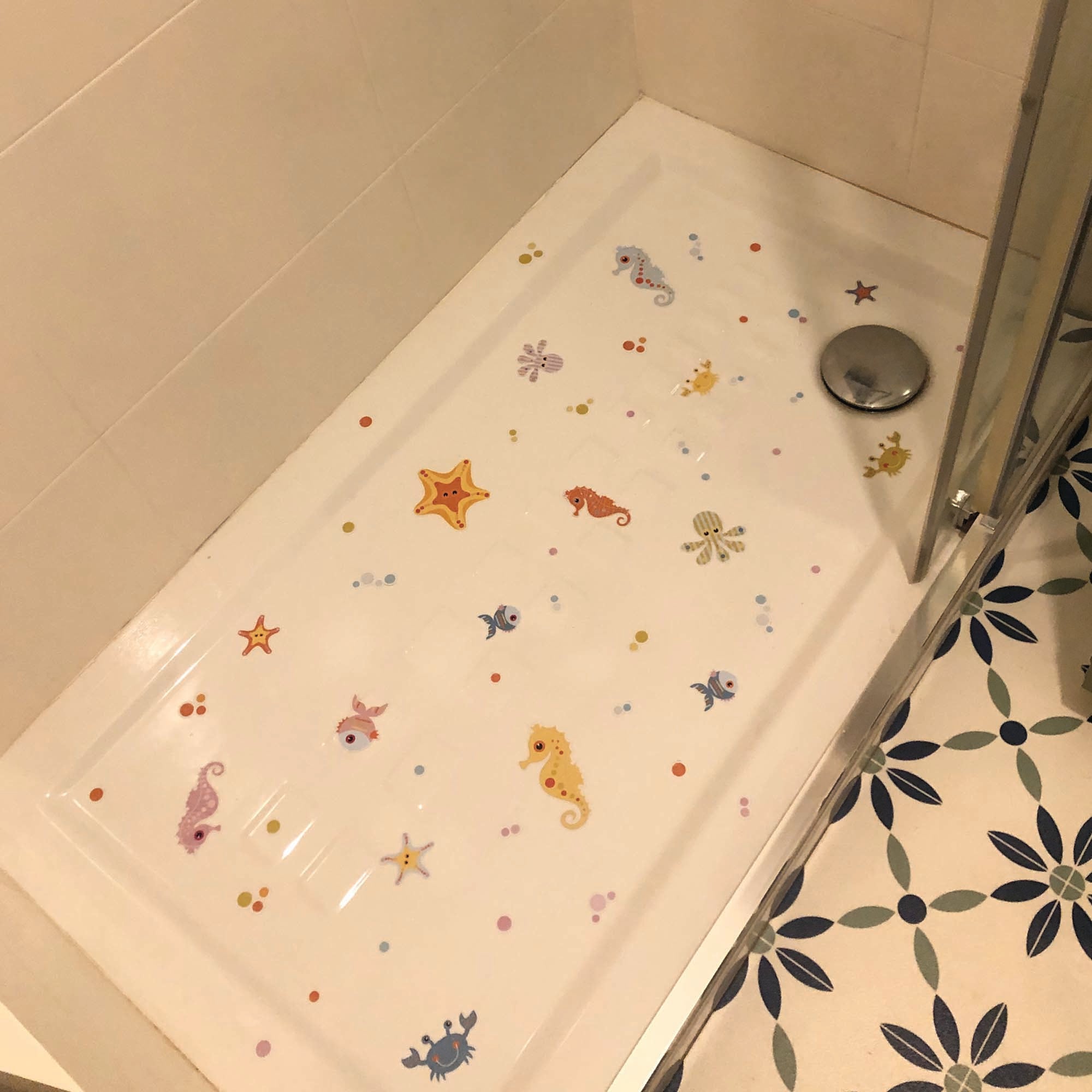 Pegatinas antideslizantes de animales marinos adheridas al suelo de una ducha, mostrando su resistencia al agua y firme adherencia. Antideslizante Animalitos del mar - Nicolasito.es