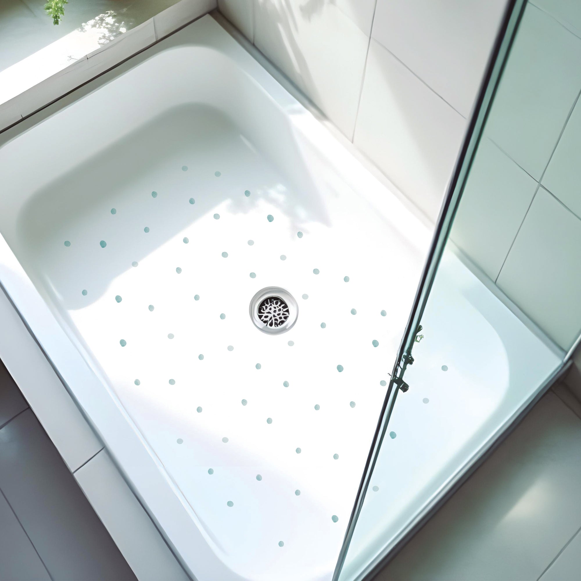 Primer plano de plato de ducha con fondo blanco minimalista y con set de pegatinas antideslizantes en forma de topitos acuarela que crea un ambiente seguro y elegante durante el baño - Nicolasito.es #color_antideslizante-topitos-aqua 