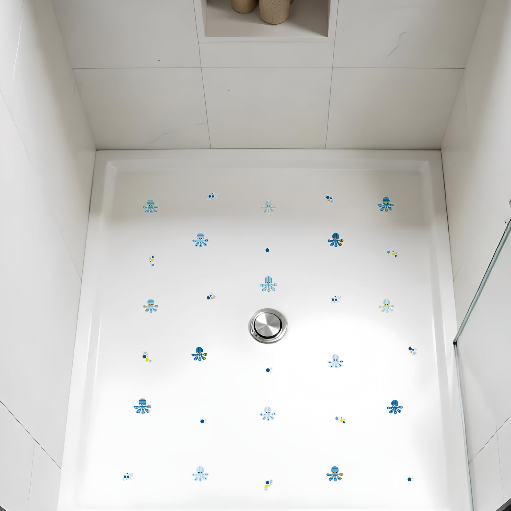 Plano de detalle de plato de ducha sobre el que se han colocado 15 pegatinas antideslizantes en forma de pulpos de color azul ue crean un ambiente seguro durante el baño - Nicolasito.es #color_Azul