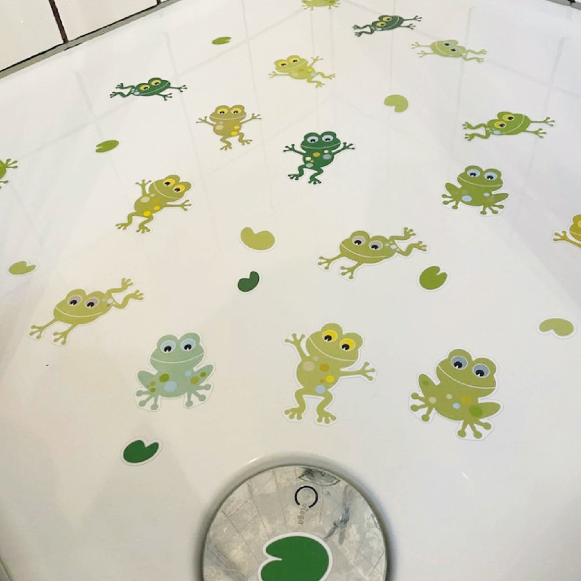 Plano de ducha con vinilo antideslizante para evitar resbalones en forma de ranas de color verde creando un ambiente seguro para el baño