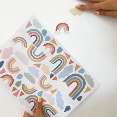 Video colocación vinilo decorativo para paredes en forma de arcoiris y nubes sobre pared de dormitorio infantil - Nicoalsito.es