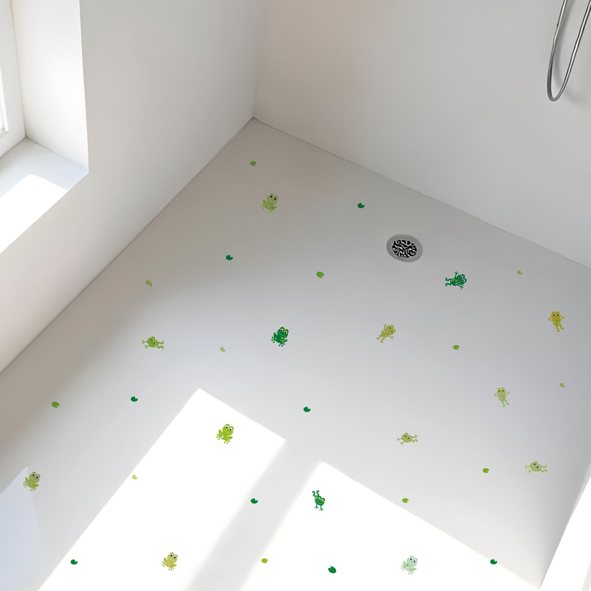 Vista general de plato de ducha con set de pegatinas antideslizantes infantiles en forma de ranitas de color verde que ayudan a evitar resbalones durante el baño creando un ambiente seguro - Nicolasito.es